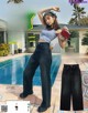 A woman standing in front of a swimming pool holding a red purse.