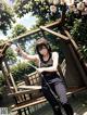 A woman sitting on a wooden bench holding a bow and arrow.