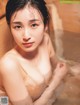 A woman in a bathtub with water on her body.