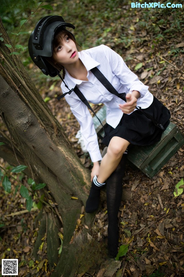 A woman in a school uniform sitting on a bench.