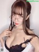 A woman wearing glasses and a white shirt.