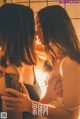 A couple of women standing next to each other in a bathroom.